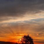 Sonnenuntergang am Horizont mit wunderschönen Sonnenstrahlen über den ganzen Himmel